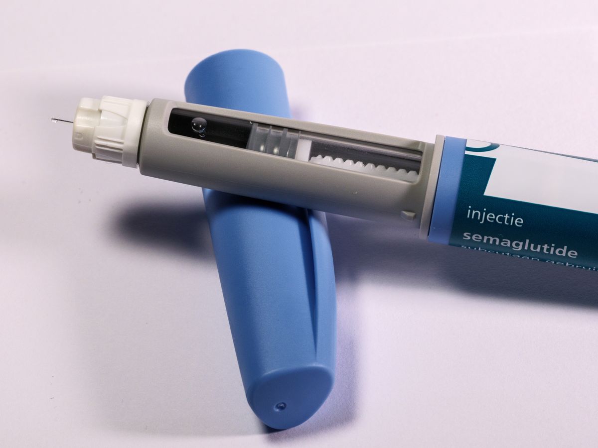 Close-up of an injection pen — needle, dose window, and label